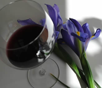 Red wine glass with Siberian Iris in background
